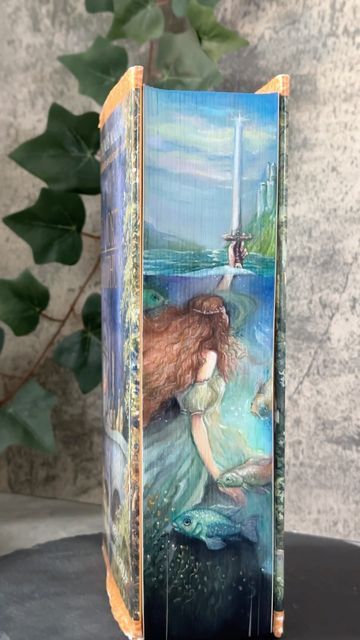 Hanna // fore-edge painter on Instagram: "Fore-edge painting on ‚Le Morte D‘Arthur‘ as a Commission. This old edition was impressive already without the painted edges. So it was a challenge to do the book justice. I think it was the longest process I ever had since I paint the edges of books and it’s so close to my heart now that it will be a bit harder than usual to give it away. But I am sure it will be in good hands! #foreedgepainting #lemortedarthur #kingarthur #ladyofthelake #excalibur #l Book Side Painting, Fore Edge Painting Diy, Book Spine Painting, Book Edge Painting Ideas, Painting On Book Covers, Book Edge Art, How To Paint Book Edges, Fore Edge Painting Books, Painted Edges Book