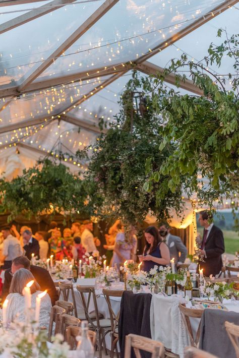 A clear marquee pictured at dusk, dressed for a wedding.   With a canopy of fairy lights,   long banquet tables with soft pretty florals and lots of candlelight. Wedding Garden Party Decorations Outdoor, Marquee Layout Wedding, Colourful Marquee Wedding, Clear Span Marquee Wedding, Marquee Garden Party, Garden Wedding Marquee, Clearspan Marquee Wedding, Rustic Wedding Marquee, Wedding Marquee Flowers