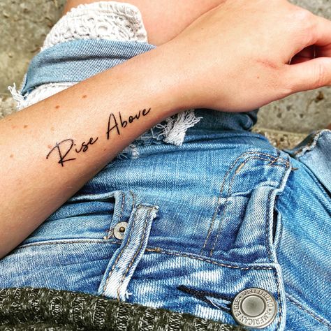 Script Wrist Tattoos For Women, Small Script Wrist Tattoos, Rise Tattoo, Still I Rise Wrist Tattoos For Women, Script Tattoo On Wrist, Still I Rise Tattoo Ideas Fonts, Rise Up Tattoo, Inside Elbow Tattoos For Women, Rise Above Tattoo