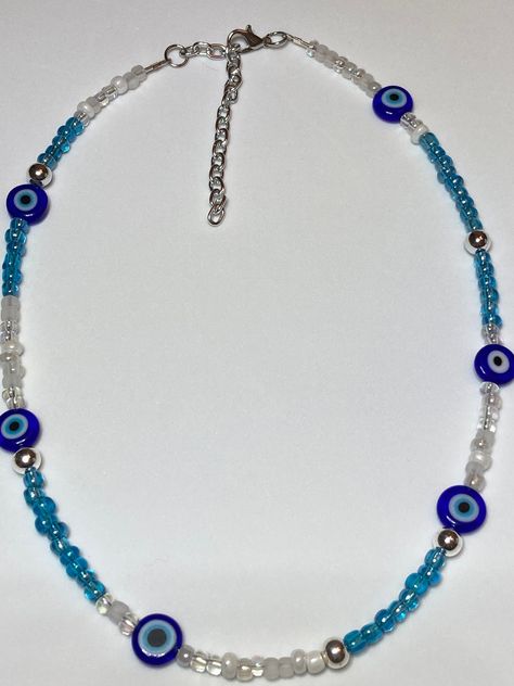 I take a portion of all sales and donate. A portion can be donated to mission fields, another time to Disabled Veterans (My Father served this Country's), Children's Hospitals, ect.. Thank you for helping me to help others.White, Blue, and Clear Seed Beads Evil Eye is Glass and 10mm Silver Metal Balls are 6mm Necklace is 15 inches and 2.5 extender Blue Evil Eye Necklace, Yellow Flower Necklace, Evil Eye Choker, Beaded Evil Eye, Funky Necklace, Necklace Evil Eye, Y2k Necklace, Golden Necklace, Jewelry Beaded