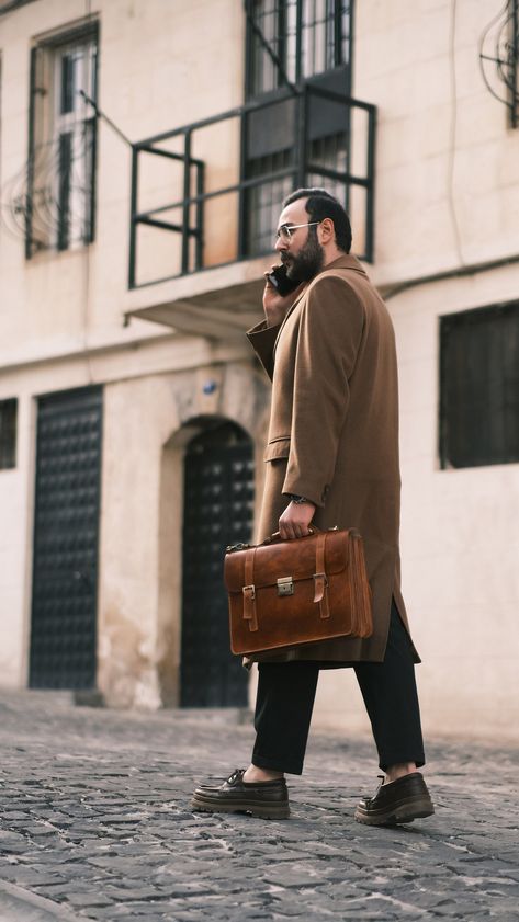 A man's briefcase can serve many functions. It is the vehicle the lawyer uses to organize and transport case files while away from the office. It's the carryall for the commuter who brings along his paperwork and computer. It's a fine alternative to the traditional backpack for the student with a sense of style. In short, a briefcase is the bag into which you can place all the various items you might need throughout the day. Because these items may include a laptop or tablet, your phone and wall Mens Laptop Bag, Mens Work Bags, Camel Leather Bag, Leather Office Bags, Leather Business Bag, Vintage Briefcase, Mens Satchel, Laptop Bag Men, Leather Briefcase Men