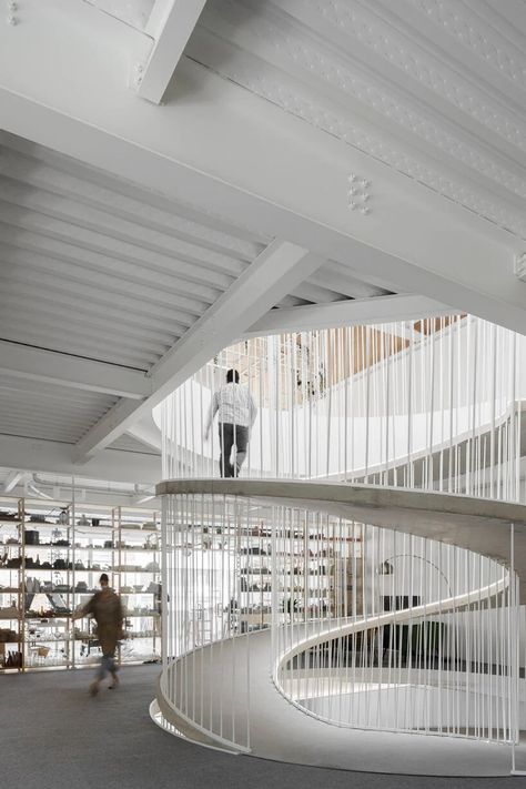 a spiral staircase connects paulo merlini's warehouse turned office in portugal Rounded Stairs, Ramp And Stairs Architecture, Urban Stairs, Mezzanine Office, Hybrid Building, Round Staircase, Ramps Architecture, Space Saving Staircase, Round Stairs