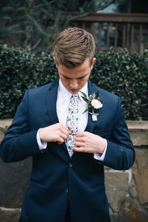 13 Stylish Mens Wedding Suit to look handsome in 2021- For Grooms Navy Blue Groomsmen Suits Floral Tie, Navy Blue Suit With Floral Tie, Navy Blue Suit Floral Tie, Ties With Blue Suits, Blue Floral Tie Groomsmen, Blue Suit With Floral Tie, Blue Suit Floral Tie, Spring Wedding Attire, Ivory Boutonniere