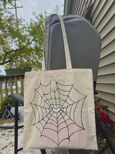 Halloween Heart Spiderweb Tote Bag, hand-painted by me! Reusable Tote Bag perfect for shopping, a school bag, an everyday bag, or trick-or-treating!  Lightweight 100% cotton canvas tote and textile acrylic paint  One Size -CARE INSTRUCTIONS- HAND-WASHING ONLY WITH COLD WATER IS RECOMMENDED Paint On Tote Bag Ideas, Tote Bag Painting Ideas Halloween, Diy Painted Canvas Bags, Canvas Bag Painting Ideas Diy, Spiderman Tote Bag, Tote Bag Inspo Paint, Simple Tote Bag Design, Painting Tote Bag Ideas, Canvas Tote Bag Painting