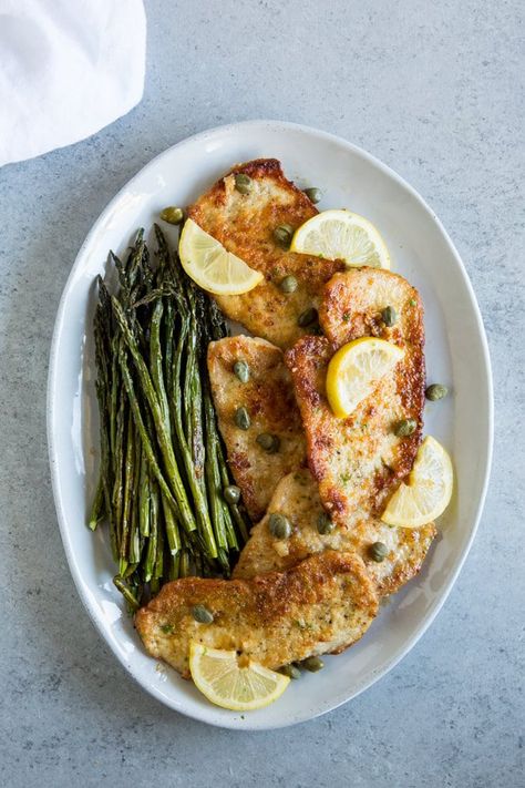 An overhead shot of Chicken Scallopini on a large gray platter with lemon slices, capers, and roasted asparagus. Chicken Breast Cutlet Recipes, Breaded Cutlets, Turkey Scallopini, Pork Scallopini, Chicken Scallopini, 15 Minute Dinners, Turkey Cutlets, Chicken Breast Cutlet, Cutlets Recipes