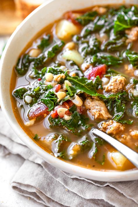 This savory Tuscan kale and sausage soup is brimming with spicy Italian sausage, kale, white beans, diced tomatoes and potatoes! | thecozyapron.com #tuscankalesoup #tuscankalesoupsausage #tuscankaleandsausagesoup #tuscankalesausagesoup #tuscansausagewhitebeanandkalsoup #tuscansausagepotatokalesoup #sausagewhitebeanandkalesoup Tuscan Kale Sausage Soup, Kale And Sausage Soup, Sausage Potato Kale Soup, White Bean Soup With Kale, Bean Soup With Kale, Kale And Sausage, Tuscan White Bean Soup, Tuscan White Bean, Soup With Kale