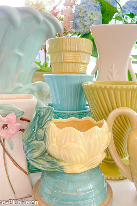 A plethora of vintage pastel McCoy pottery pieces including: flower pots, vases, pitchers and a frog planter. Pastel Pottery, Amazing Pottery, Pottery Display, Average Joe, Antique Pottery, Mccoy Pottery, Vintage Planters, Blue Heron, Green Ceramics