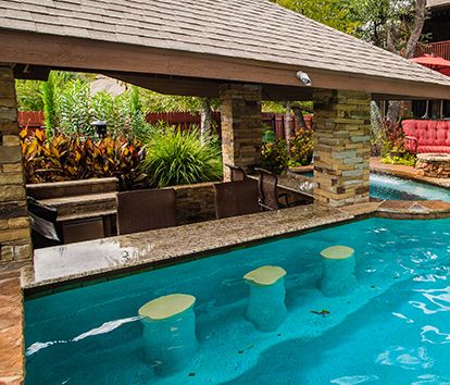 Swim-Up Bars are a great way to bring the fun of having a cocktail or food served to you in the pool because if you don’t have to get out why would you? These areas feature built-in bar stools made of stone, tile or precast finishes and a bar that can be adorned in glass tile or beads. The options are endless. Pool With Bar Stools, Swimup Bar Swimming Pools, Outdoor Pool Showers, Pool With A Bar, Swim Up Bar Pool Backyards, Swim Up Pool Bar Ideas, Pool Bar Stools, Swim Up Bar Pool, Pool Stools