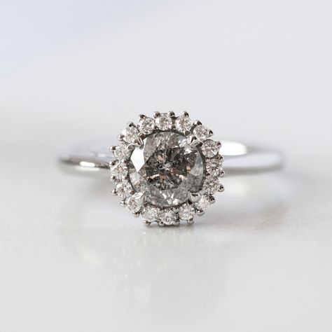 Platinum engagement ring with a round salt & pepper diamond centre stone, surrounded by a halo of white diamonds in a claw setting. Grey Moissanite Engagement Ring, Different Engagement Rings, Grey Diamond Engagement Ring, Wedding Rings Ideas, Gray Ring, Salt Pepper Diamond, Our Galaxy, Future Engagement Rings, Colored Engagement Rings