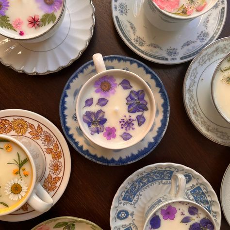 Vintage teacups with white candle wax inside. This version showcases real flowers for decoration on the top of the candles. The teacups are placed on saucers and photographed from a view looking down to showcase the flowers on the top of the teacup. These flowers are purple, white, pink, light blue. The teacups are royal blue and white, white and yellow, and white with various designs adorning them. Candles In Teacups, Candle Tea Cups, Diy Teacup Candles, Cute Crafts Gifts, Candle In A Mug, Vintage Teacup Candle, Teacup Candles Diy, Teacup Upcycle, Candles In Tea Cups