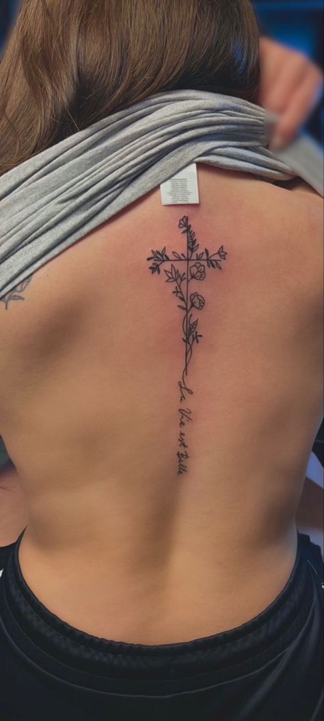 Cross On Back Tattoo Woman, Flower Cross Spine Tattoo, Southern Spine Tattoos, Spine Tattoos With Cross, Daisy Tattoo Spine, Feminine Patriotic Tattoos, Little Spine Tattoos, Back Tattoo Women Cross, Biblical Spine Tattoos