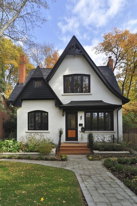 Modern bungalow with pointed roof and autumnal surroundings. Modern bungalows combine cozy charm with sleek design, proving that small spaces can deliver big style and functionality. Bungalow Aesthetic, Modern Bungalows, Cottage Houses, Black Window Frames, Small Bungalow, Bungalow Cottage, Orange Door, Terracotta Roof, Stucco Walls