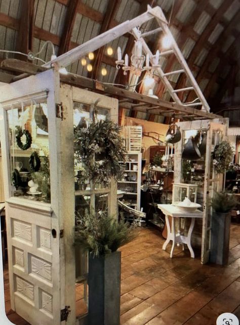 Wreath Market Display, Vintage Booths Ideas, Antique Fair Booth Display, Rustic Shop Display, Spring Retail Display Ideas, Garden Flag Display Ideas Retail, Farmhouse Vendor Booth Display Ideas, Retail Greenhouse Display Ideas, Vintage Store Displays Boutiques