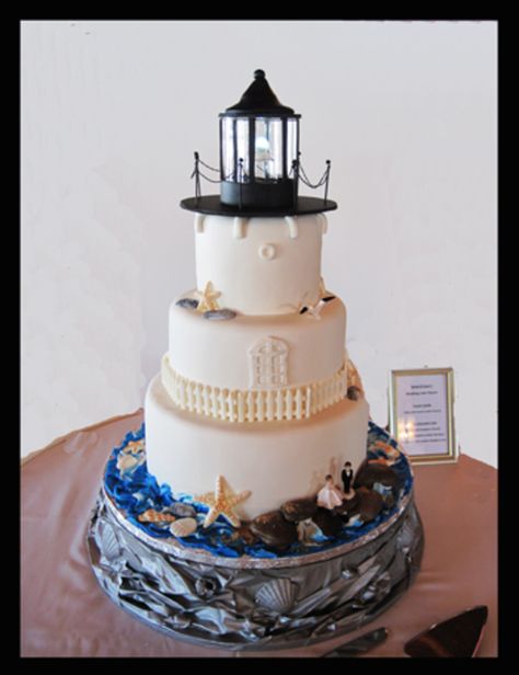 Lighthouse Wedding Cake Lighthouse Wedding Cake I made the stand out of crinkled paper, glue and seashells then spray painted it silver. Shells and fence on the... #featured-cakes #leannew #cakecentral Lighthouse Wedding Theme, Lighthouse Cake, Nautical Wedding Cakes, Crinkled Paper, Crushed Paper, Lighthouse Wedding, Light Fairy, Nautical Cake, Round Wedding Cakes