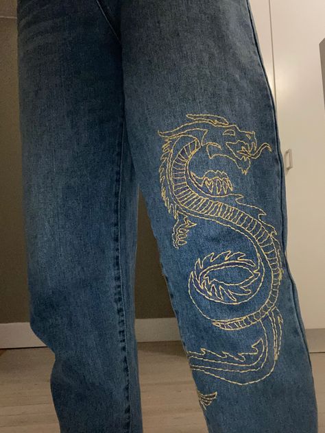 Dragon embroidered on a jeans Dragon Jeans Paint, Dragon Embroidery Jeans, Embroidered Words On Jeans, Embroidery Designs In Jeans, Black Embroidered Jeans, Embroidered Jeans Ideas, Fabric Paint Jeans, Embroidered Jeans Aesthetic, Embroidered Pants Diy