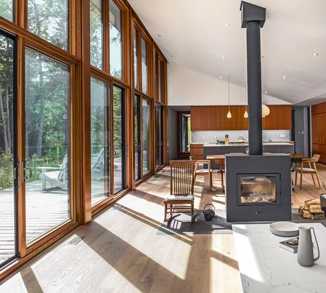 Large south-facing windows by Loewen and a high-efficiency Rais X wood-burning stove help to reduce energy demands. Wood For Ceiling, Biophilic Living Room, Mountain Cottage Interiors, South Facing Windows, Cottage House Interior, Fireplace Windows, Hamptons Cottage, Cottage Interior Design, Solar Power House