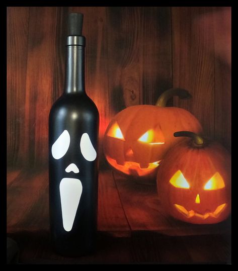 Scary Ghost Face-Halloween-Lighted Wine Bottle-Gift-Home Décor-Halloween Gift-Halloween Décor  This bottle is a perfect addition to your Halloween décor!  It would also make a great gift for family or friends or a scary Halloween party centerpiece. THE BASICS This is a clear, standard 750 ml, glass wine bottle, painted transparent black with white vinyl, and cool white LED cork lights. With the black transparent paint you can see the lights when it is lit up but when the lights are off, it looks Black Painted Wine Bottles, Halloween Wine Bottle Crafts, Halloween Party Centerpieces, Halloween Wine Bottles, Halloween Bottles, Scary Ghost, Halloween Arts And Crafts, Diy Glass Bottle Crafts, Party Centerpiece