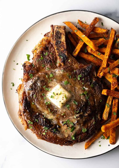 Large bone in ribeye steak on a plate with sweet potato fries. Steak On The Stovetop, Bone In Ribeye Steak, Reverse Sear Ribeye, Rare Meat, Best Steak Seasoning, Rib Eye Recipes, Christmas Main Dishes, Ribeye Steak Recipes, Night Dinner Recipes