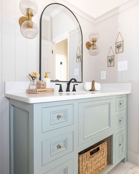 Experience serene sophistication in this modern bathroom, featuring light blue cabinetry, a graceful arched mirror, and a touch of vintage charm. A perfect blend of tranquility and timeless style.   Builder @apex_constructions_specialty   Design @hawkinsandgraydesign   Photo @lyndseymariephotography   Cabinetry @luxecabinetryanddesign       @breannagriswoldsdesigns   @klaserandco   @christinahalldesigns   @hawkinsandgray_organizing Light Blue Bathroom Vanity, Light Blue Bathroom, Blue Bathroom Vanity, Arched Mirror, Blue Bathroom, Gray Design, Feature Light, Cottage Core, New Builds