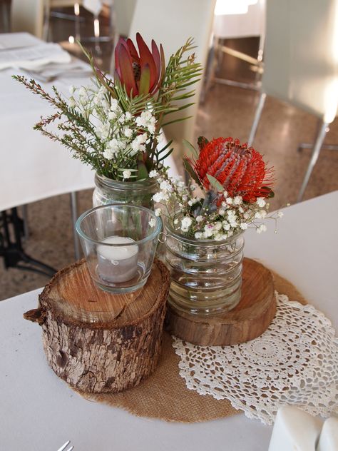 rustic stumps as wedding centrepieces with Australia native flowers Native Table Arrangements, Bush Wedding Ideas, Aboriginal Wedding, Recycled Wedding Decorations, Bush Dance, Sept Wedding, Native Wedding, Recycled Wedding, Flower Table Decorations