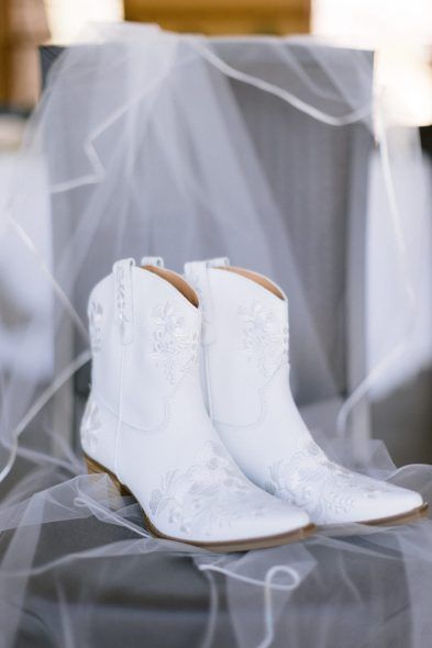 In true mountain girl fashion, Emma changed into delicate white-laced cowgirl boots. Cowgirl Boots For Wedding Dress, Simple Wedding Dress With Cowgirl Boots, White Boots For Wedding, White Cowgirl Boots With Wedding Dress, Cowgirl Boots Bride, Womens Wedding Boots, White Cowboy Boots Bride, Bridal Cowboy Boots Wedding, Wedding Shoes Cowgirl Boots