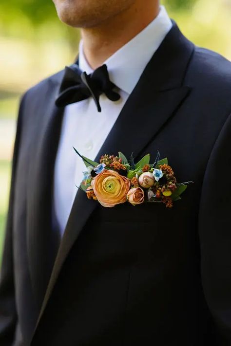 a classic black tux and a bold pocket square styled with peachy, rust and blue flowers, greenery and thistles is wow Pocket Square Boutineer Ideas, Pocket Boutonniere Black Suit, Groom Flower Pocket Square, Groom Floral Pocket Square, Men’s Wedding Boutineer, Boutineer Pocket Square, Boutonniere Pocket Square, Pocket Bouquet, Pocket Boutineer