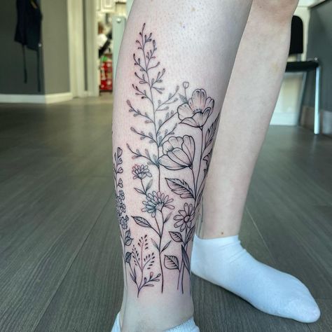 #flowers #legwraptattoo #fineline #wildflowertattoo #calvetattoo #longstems #hand-drawn #femininetattoo #beautifultattoo Floral Tattoo Design Calf, Flowers On Calf Tattoo, Birth Flower Tattoos On Leg, Flower Wrap Ankle Tattoo, Botanical Leg Wrap Tattoo, Flower Around Ankle Tattoo, Flowers Wrapped Around Ankle Tattoo, Flowers Calf Tattoo, Flower Garden Leg Tattoo