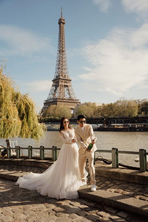 A couple popping the champagne on the banks of the Seine River with Eiffel tower during Pre Wedding photoshoot Fluffy Wedding Dress, Wedding Paris, Pop The Champagne, Paris Elopement, Parisian Wedding, Seine River, The Seine, Paris Wedding, Dream Wedding Ideas Dresses