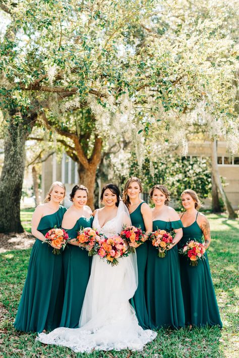 Classic Bride and Bridesmaids Outdoors in Mix and Match in Emerald Green Dresses Holding Vibrant Colorful Pink, Orange and Red Floral Bouquets | Wedding Venue Tampa Garden Club | Tampa Bay Wedding Florist Monarch Events and Design Bouquet With Emerald Green Dress, Emerald Green And Fuschia Wedding Decor, Bouquet For Emerald Green Dress, Emerald Pink Orange Wedding, Emerald Summer Wedding, Emerald And Coral Wedding, Emerald Green And Coral Wedding, Prom Boquets, Emerald Green Summer Wedding