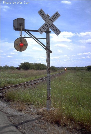 South Orient Wig-Wag: South of Coleman, TX A wig-wag begins to move as a westbound South Orient train approaches Highway 1026 on June 13, 2000. Photo by Wes Carr Railway Crossing, Adachi Tohru, Railroad Lights, Rural Railway Station, Rural Train Station, Circle Signs, Train Stations Vintage, Conrail Railroad, Railroad Lanterns