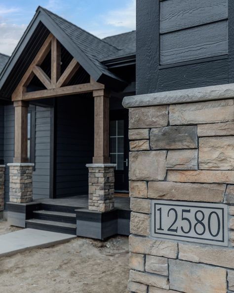 Wood Siding And Stone Exterior, Brick On Bottom Of House Exterior, Iron Ore And Stone Exterior, Deep Cavern Mastic Siding, Dark Grey Siding Black Windows, Dark Brown Barndominium Exterior, Dark Stone Exterior Houses, Black House With Stone, Dark Siding House