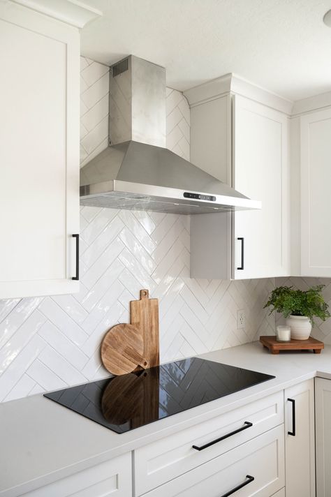 White Kitchen And Backsplash, White Tiled Backsplash, White Black Splash Kitchen, Kitchen Backsplash With Grey Countertops, White Kitchen Cabinets Black Countertops Herringbone Backsplash, Kitchen Tiles Backsplash White Cabinets, Hearing Bone Backsplash Kitchen, Hair And Bone Backsplash, White Backsplash For Kitchen