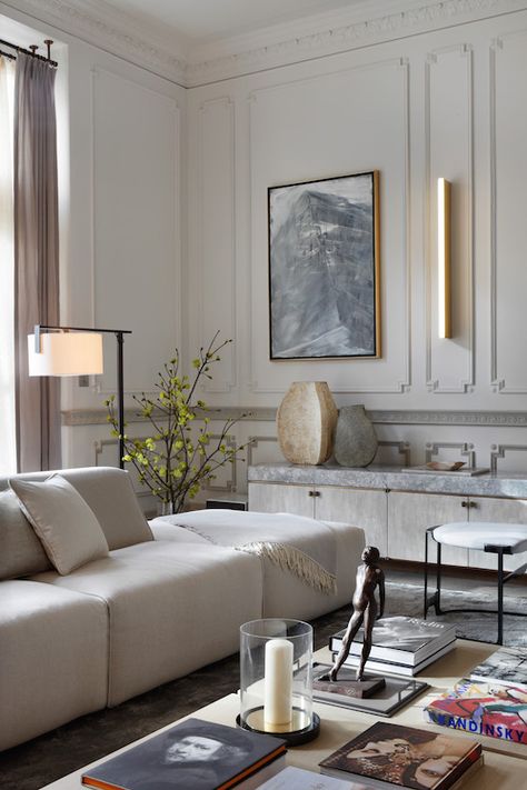 A custom handmade credenza lines one wall of this London drawing room by Janine Stone. The piece, covered in a fine crackle gesso, rests on a cast-bronze base and is topped with pale Moonrock marble from the quarries of northern Italy. The large-scale sofas in pale oyster velvet provide comfortable and inviting seating, and the cool color scheme sets a restrained mood for a client who wanted “to ensure the home creates a welcome retreat, conveying a sense of harmony and gentle calm.” Kensington House, British Interior, Design Salon, Trendy Living Rooms, Decoration Inspiration, Decor Minimalist, Living Room Grey, Classic Interior, Contemporary Living Room