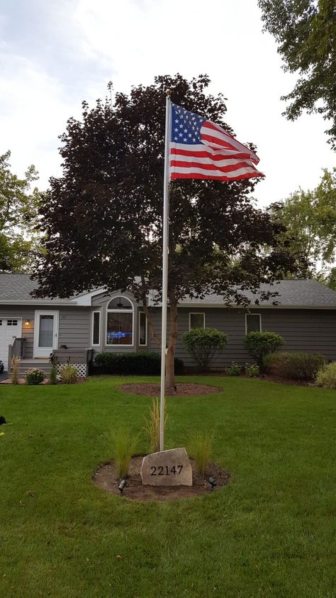 American flag pole with flag stone address and tall grass. American Flag Front Yard, American Flag Pole In Yard, Flagpole Garden Ideas, American Flag Pole Landscaping, Flag Pole In Front Yard, Landscaping Around Flag Pole, Landscape Around Flag Pole Yard Ideas, Flagpole Ideas Front Yards, Front Yard Flag Pole Ideas