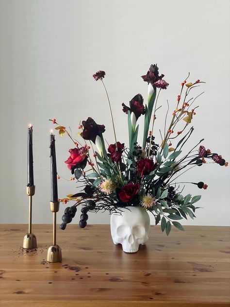 Transform your space into a hauntingly beautiful scene with this Halloween-inspired silk flower arrangement. Featuring lifelike irises and roses, this composition combines the elegance of fall blooms with a touch of spooky charm. Each flower is crafted from high-quality, real-touch materials, ensuring they look and feel just like the real thing Dimensions: Approximately 24" wide and 26" tall. Do the measurements not fit you? Just send me a message with the sizes you need, and I'll be able to create a composition that suits you 🌸 Handmade with Care: We pour our heart into crafting each arrangement, guaranteeing its quality and beauty. 🏡 Versatile Home Decor: Perfect for brightening up any room in your home, from the living room to the bedroom or even your office. This stunning arrangement Moon Flower Arrangement, Skull Floral Arrangement, Fake Flower Arrangements Diy Ideas, Spooky Flower Arrangements, Dark Flower Arrangements, Black Flower Arrangements, Fake Flower Arrangements Diy, Halloween Flower Arrangements, Candelabra Flowers