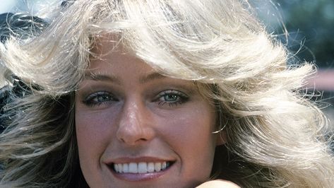 1970s Feathered Hair Is Far From Extinct—Here’s How To Style It in 2020 Old School Hairstyles, Large Hair Rollers, Flipped Ponytail, 2022 Makeup, Feathered Hair, Feathered Bangs, Barrel Curls, Big Curls, Farrah Fawcett