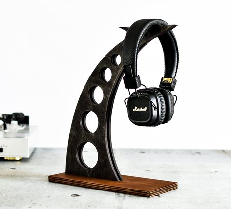 Headphone stand for audiophile, Unique design for loft - Made of plywood - Simple loft design, solid and functional Dimension; - height 30 cm (about 12 inches) - depth 23 cm (about 9 inches) -width 10 cm (about 4 inches) Stand was painting by stain (black and brown) Colour could be a little different than picture shows. Product requires assembly (base is separately, glue included) Thanks for visit in my shop Headphone Stand Ideas, Wooden Headphone Stand, Headphone Stand, Diy Headphone Stand, Industrial Lamp Design, Mens Room Decor, Headset Stand, Bracelet Stand, Headphone Holder