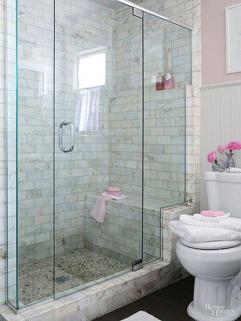 walk-in shower that enhances a usefulness and beauty. This shower stands out in a simply furnished bath, thanks to its distinctively tiled walls and river-rock-tiled floor that are easily seen through a frameless glass shower enclosure. The glass enclosure stair-steps up a marble frame, highlighting the shower bench and a toiletry shelf that aligns with the beaded-board wainscoting's upper trim. #BathroomShower Small Bathroom With Shower, Bad Inspiration, Master Bath Remodel, Small Bath, Bathroom Redo, Bath Room, Shower Remodel, Bathroom Remodel Master, Bath Remodel