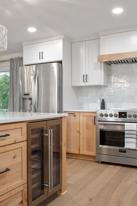 A mix of Knotty Alder lower cabinets and painted Wider White (SW 7014) upper cabinets give this Portland kitchen remodel an updated look. Matte Black accents pop against the subtle color palette. 42 Inch Upper Cabinets Kitchen, White Oak And Black Kitchen Cabinets, Two Tone Kitchen Cabinets Wood And White, Two Tone Kitchen Cabinets Wood, White Upper Cabinets Wood Lower, Knotty Alder Kitchen Cabinets, Alder Wood Kitchen Cabinets, Knotty Alder Kitchen, Alder Kitchen Cabinets