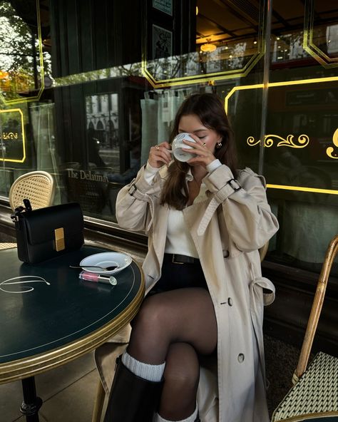 This cafe gives me the Parisian feel ☕️ #effortlesslychic #chicoutfit #falloutfit #falloutfits #falloutfitideas #falloutfitinspo #fallfashion #trenchcoat #elegantoutfit old money aesthetic, modern chic style, timeless fashion, preppy french, parisian, london fashion, classic outfit, London, street style, feminine chic style Modern French Outfit, Parisian Cafe Outfit, Winter French Outfits Parisian Style, Cafe Outfit Aesthetic, French Girl Aesthetic Outfit, French Outfit Style Parisian Chic, Parisian Chic Aesthetic, Feminine Chic Style, Cafe Outfit