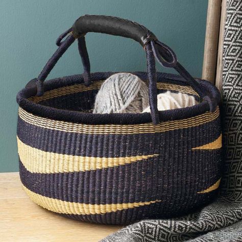 Deftly woven by artisans working near Bolgatanga in northern Ghana, this low, handled elephant grass basket in natural and indigo-dyed navy has ample room for carrying market produce, or for stylish storage at home. Sturdy handle has leather wrap. 9 1/2h x 16dia Grass Weaving, Grass Basket, Bolga Basket, Garden Basket, Basket Case, Market Basket, Straw Basket, Toy Basket, Primary Bedroom