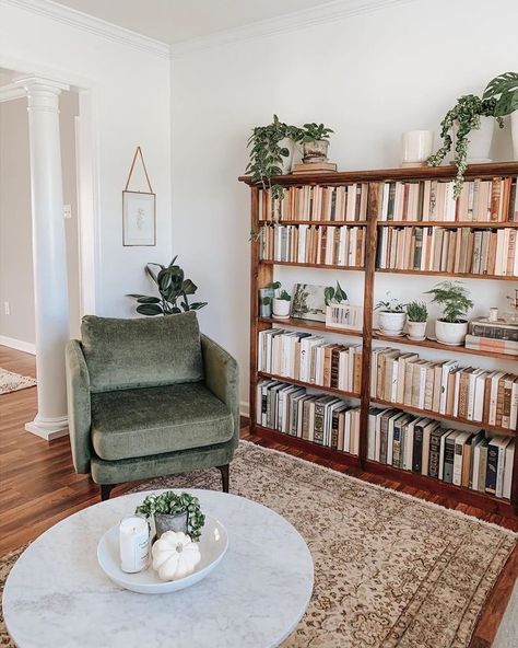 the round coffee table not only adds much needed mass to the center of the room to balance out the bookshelf and chair, but it adds a contrasting shape to the rectilinear bookshelf. Reading Area In Office, Bookshelf In Office, Big Bookshelf, Vintage Industrial Interior Design, Bookshelf Dimensions, Books And Plants, Lots Of Books, Modern Boho Living Room, Office Area