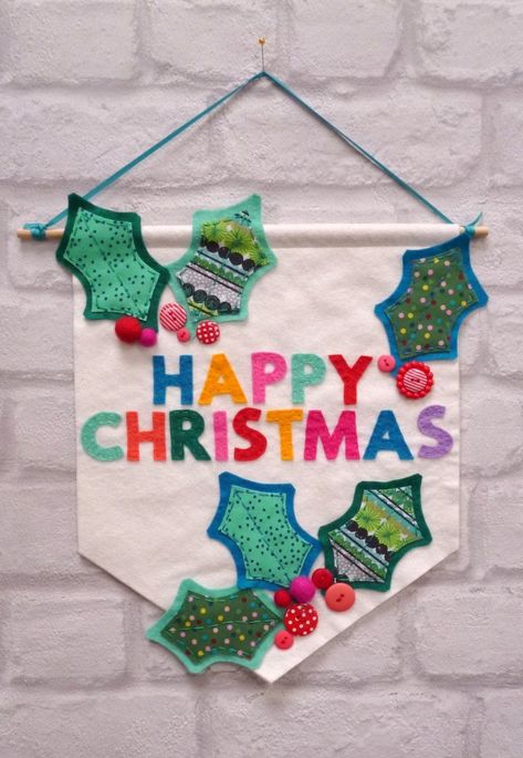 "Say Happy Christmas to all your visitors in style! Our Happy Holly Christmas Banner Kit makes a bright and cheerful statement. The banner is 10\" x 12\" (25cm x 30cm) the wooden dowel is 30cm long This kit contains everything you need to make a Happy Christmas banner:  A pre-made handmade banner, premium wool blend felt, fabric felt, buttons, ribbons, felt balls, thread and glue.   We also include a couple of needles and pins but you do need your own scissors. Photo instructions and hand drawn Merry Christmas Bunting, Textile Christmas Decorations, Christmas Fabric Decorations, Christmas Banners Ideas Diy, Christmas Bunting Ideas, Happy Christmas Banner, Christmas Banner Diy, Happy Christmas To All, Mistletoe And Wine