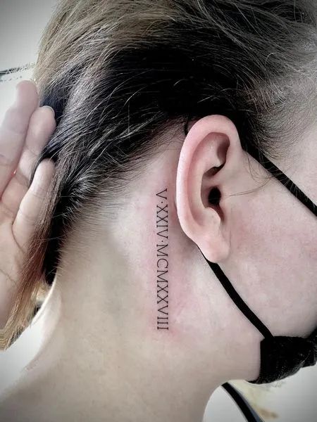 Roman Numeral Neck Tattoo Roman Numeral Tattoo Back Of Neck, Birthdate Neck Tattoo, Roman Numerals On Neck, Roman Numeral Ear Tattoo, Roman Numeral Neck Tattoos Women, Roman Numerals Tattoo Behind Ear, Behind The Ear Roman Numeral Tattoo, Roman Numeral Tattoo For Women, Numbers On Neck Tattoo