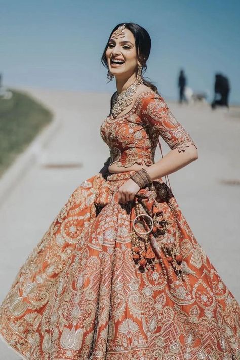 Indian bride in a rusty orange lehenga Bridal Lehnga Unique, Lehenga Designs 2023, Different Shades Of Orange, Red Bridal Lehenga, Best Indian Wedding Dresses, Orange Lehenga, Bridal Lehenga Designs, Indian Outfits Lehenga, Wedding Lehenga Designs