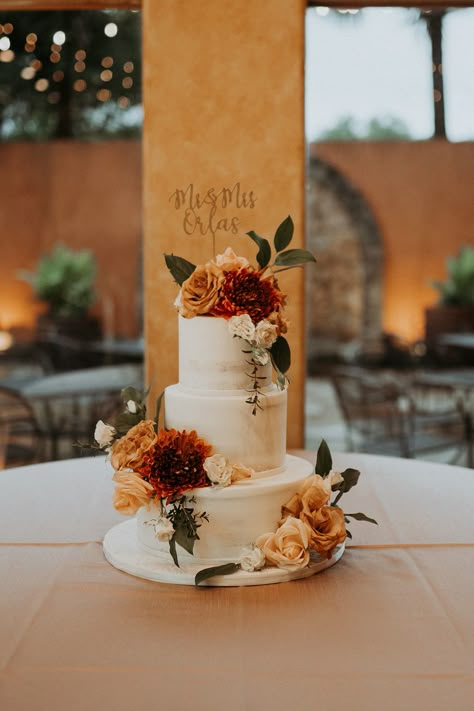 Fall in love with this jaw-dropping naked wedding cake adorned with the most captivating burnt orange, red, and green fall flowers. Your taste buds are in for a sweet treat at Agave Estates, the ultimate wedding venue in Katy, Texas. Photography: JoAnn Marie Photography #weddingcake #weddingvenue #venue #nakedcake #katytx #houston #wedding Fall Wedding Cake With Flowers, Burnt Orange And Green Wedding Cake, Sage Green And Burnt Orange Wedding Cake, Burnt Orange Wedding Cakes, Green And Orange Wedding Cake, Earth Tone Wedding Cake, Marigold Wedding Cake, Wedding Cake With Fall Flowers, Rust Wedding Cake