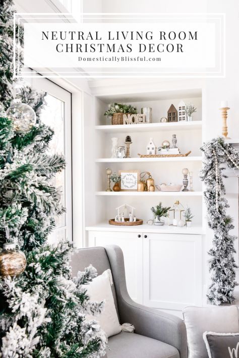 A Neutral Living Room Christmas Decor home tour with flocked garland, a flocked Christmas tree, and a cozy glider by the fireplace to snuggle up in and read Christmas stories. | Two-story living room decorations. | White living room Christmas decorations. | White built-ins with Christmas decorations. | How to decorate bookshelves for Christmas. | Two-story fireplace decor. | Christmas garland on a fireplace mantel. | Large mirror above a fireplace. | Simple Christmas decor. Neutral Pink Christmas Decor, Fireplace Built Ins Christmas Decor, Built In Christmas Decorations, Winter Built In Decor, Christmas Decor Ideas For Built Ins, Christmas Fireplace Shelves Decor, Built In Shelf Christmas Decor, Christmas Decor On Built In Shelves, Shelf Decor Living Room Christmas