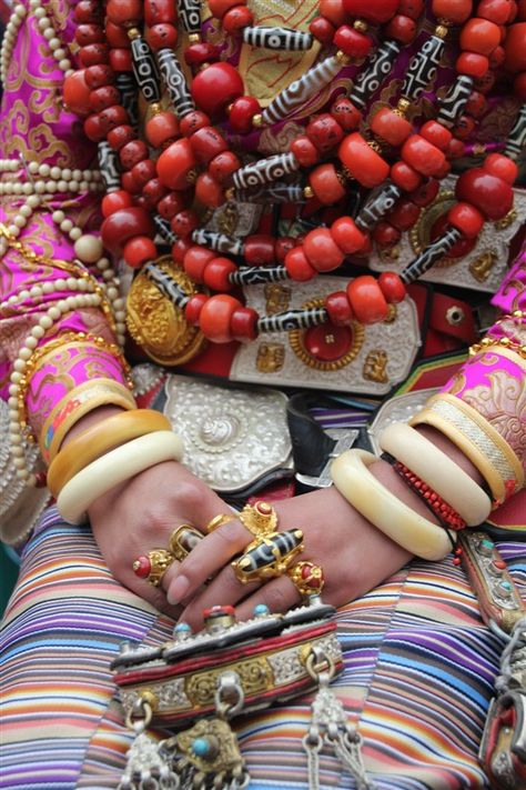 Government Celebrations in Kangding, Kardze, Tibet, A Khampa Tibetan girl in a traditional ceremonial costume from Palyul county. She wears the traditional women's headdress in Palyul with many strands of turqoise, and a gold necklace across her forehead, nine necklaces of coral and contemporary dzi, and coral and dzi beads set gold rings on six fingers. Maori Tattoos, Tibetan Jewelry, Traditional Jewellery, Ethnic Necklaces, Bhutan, World Cultures, People Of The World, Ethnic Jewelry, Traditional Clothing