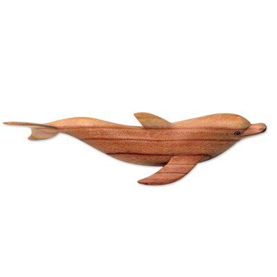 Eka pays tribute to the playful and intelligent bottle neck dolphins that swim off Lovino Beach on Bali's north coast. Carved by hand, the sleek marine mammal is depicted in a jempinis wood figurine. | Bay Isle Home™ Risher Realistic Artisan Carved Bottle Nose Dolphin Wood Figurine Wood in Brown, Size 4.0 H x 12.3 W x 3.5 D in | Wayfair | Home Decor | Black Friday / Cyber Monday Deals Bottle Nose Dolphin, Family Sculpture, Bottlenose Dolphin, Marine Mammals, Buy Wood, August 11, North Coast, Mantel Decorations, Boho Chic Decor