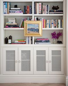 Make the bottom cabinet doors on the built-in like this with a decorative metal mesh to sort of 'hid' the electronics and put glass or plexi in there to keep the dog hair and dust out? Diy Radiator Cover, White Bookshelves, Living Tv, Bookcase Styling, Bookshelf Styling, Nate Berkus, Radiator Cover, Built In Bookcase, Built In Shelves